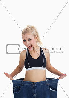 Thin woman wearing old pants after losing weight