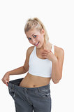 Young healthy woman wearing old pants after losing weight