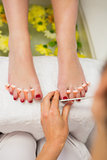 Woman polishing toe nails at spa center