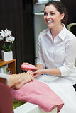 Woman buffering toe nails at spa center
