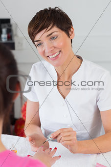 Closeup of woman applying nail varnish to finger nails