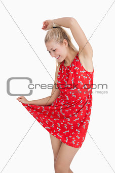 Young woman in red summer dress dancing