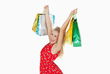 Portrait of cute excited woman holding up her shopping bags