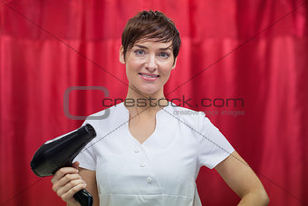 Female hairdresser holding hair dryer