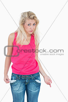 Sad young female showing her empty pockets