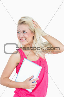 Happy casual young woman with digital tablet looking away