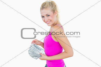 Young casual woman with fanned us banknotes