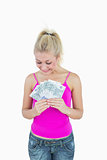 Happy young woman looking at fanned euro banknotes