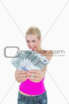 Woman holding out fanned 100 euro banknotes
