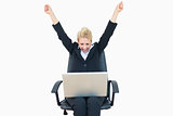 Successful business woman raising hands in victory with laptop