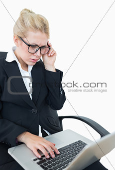 Worried young businesswoman using laptop