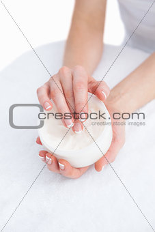 French manicured hands applying cream