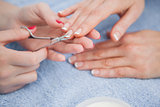 Woman cutting fingernail with scissors