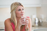 Closeup of young thoughtful woman with coffee cup