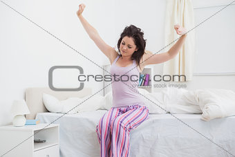 Sleepy woman stretching her arms in bed