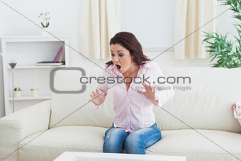 Shocked expressive woman sitting on couch