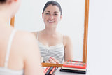 Happy woman looking at self in mirror