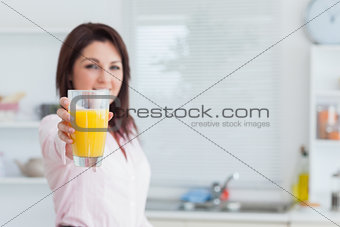 Smiling woman offering you orange juice