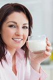 Closeup of young woman with glass of milk