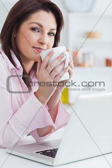 Portrait of woman with coffee cup and laptop