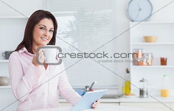 Woman with coffee cup and digital tablet