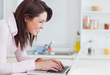 Side view of happy young woman using laptop