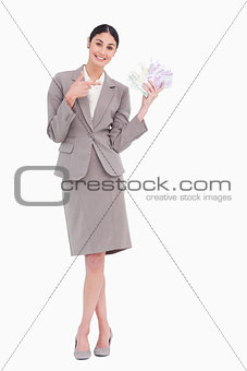 Portrait of happy business woman pointing at banknotes