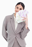 Portrait of happy business woman holding fanned banknotes