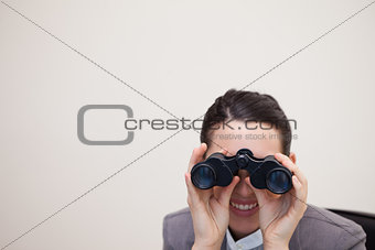 Business woman looking through binoculars