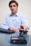 Business man using telephone at office desk