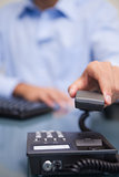 Closeup of man with telephone receiver at desk