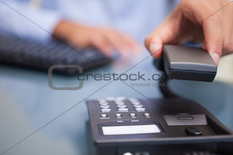 Man with telephone receiver at desk