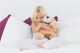 Little girl embracing her teddy bear