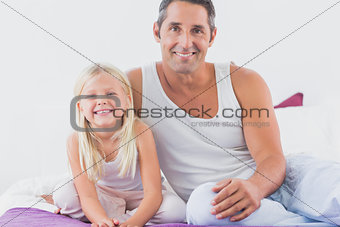 Father and his daughter sitting on a bed