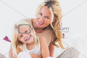 Mother and her daughter sitting on a bed