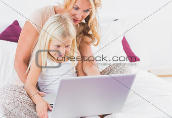 Mother and her daughter watching a laptop screen