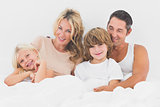 Family lying on a white bed