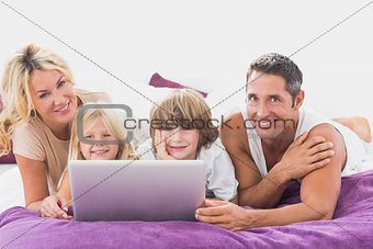 Smiling family using laptop