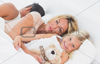 Family lying together on a bed