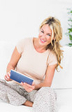 Smiling blonde woman using her tablet pc