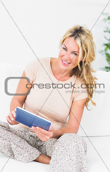Smiling blonde woman using her tablet pc