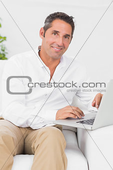 Cheerful man typing on the laptop