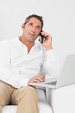 Man using his laptop while phoning