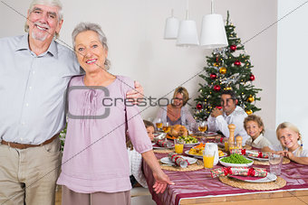 Grandparents standing by the dinner table