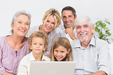 Family smiling in front of a laptop screen