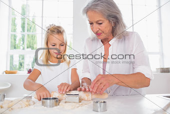 Grandmother and granddaughter making biscuits