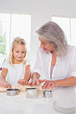 Granddaughter making biscuits with her grandmother