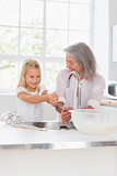Smiling grandmother and granddaughter washing hands