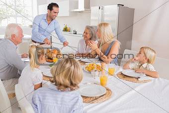 Smiling father proposing a slice of turkey