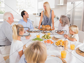 Family looking at the mother with a turkey plate